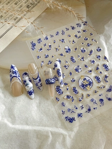 Detail of blue porcelain nail stickers with gold edges and vintage Chinese floral patterns