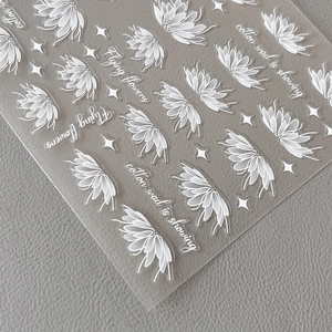 White floral nail art stickers with lotus designs and stars on transparent backing