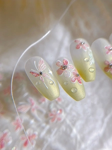 Dettaglio macro di adesivi per unghie fiori 3D con farfalla rosa e accenti di strass