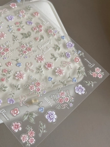 Detailed macro view of 3D embossed floral nail stickers in Morandi colors with textures