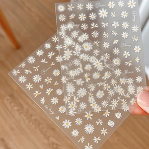3D embossed white daisy nail art stickers with Flower and Daisy lettering on wood background