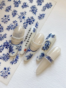 Detail of blue and white porcelain nail stickers with gold accents and Chinese calligraphy