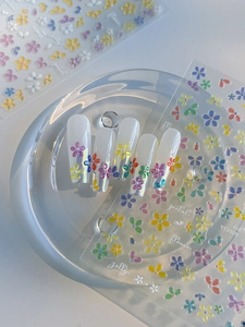Detail showing 3D jelly flower nail stickers with tiny pearls on iridescent long nails
