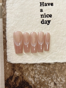 Dettaglio di unghie finte French cat-eye rosa nudo con punte bianche e finitura perlata