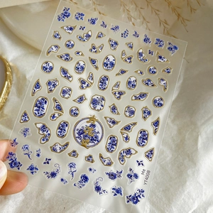 Blue porcelain nail art stickers with gold foil floral patterns and lucky symbols