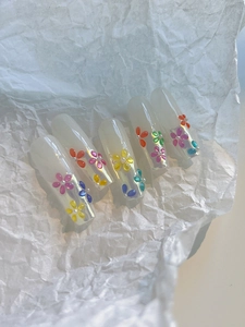 Detailed macro view of 3D colorful jelly floral nail art with mini white pearls