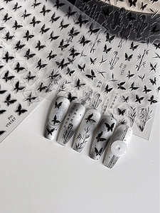 Detail of black butterfly and bamboo nail stickers with ink style on manicured tips