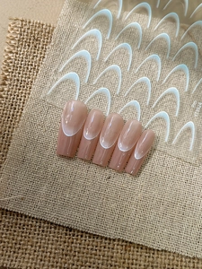 Dettaglio di adesivi per unghie nude pink french con punte bianche e guida per il design