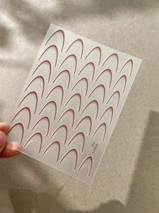 Dettaglio macro di adesivi per manicure francese bordeaux con 24 strisce curve trasparenti