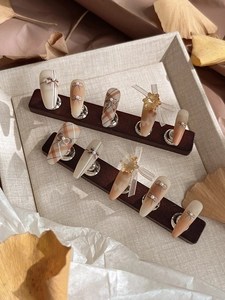 Detailed macro view of 3D bow and pearl ornaments on autumn style press-on nails