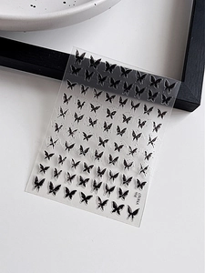 Close-up of black butterfly nail art stickers with vintage Chinese style patterns