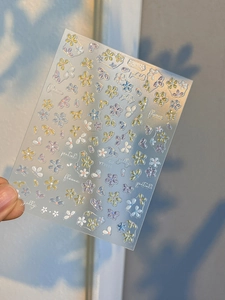 Macro shot of 3D colorful five-petal flower nail stickers with artistic lettering