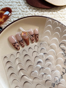 Detailed view of leopard print press-on nails with 3D bows and french manicure stickers
