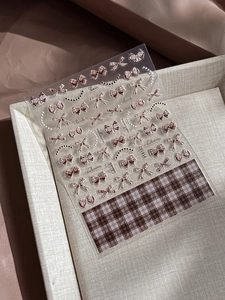 Detail view of retro brown plaid bow nail art stickers with 3D embossed texture