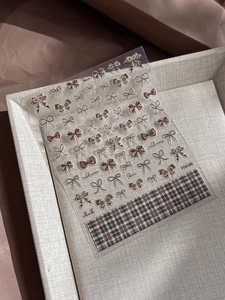 Detailed view of self-adhesive nail stickers with bow patterns and autumn check designs