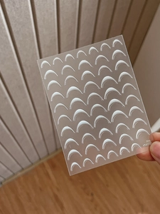 Close-up of YT4172 white crescent French manicure nail stickers on a clear backing sheet