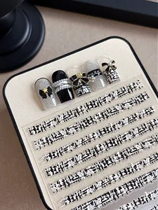 Close-up of elegant textured nail art stickers with bow charm and silver diamond detail