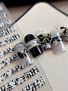 Macro shot of festive nail stickers with houndstooth pattern and Merry Christmas text