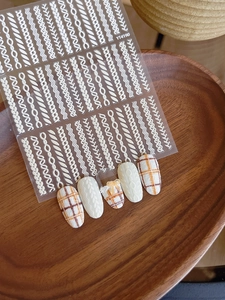 Detail view of 3D embossed knitting patterns nail stickers with warm winter style art