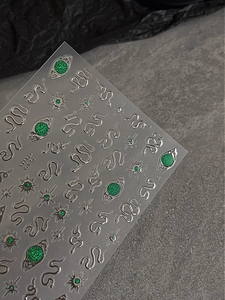 Detailed view of 3D emerald green snake and star embossed nail art stickers