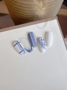 Detail of blue tweed nails with textured 3D embossed sweater pattern and bows