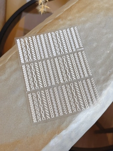 Macro detail of YT4190 white embossed nail stickers with 3D winter knit and cable textures