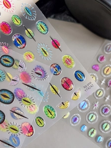 Macro detail of laser glitter evil eye nail art stickers with 3D cat eye effect textures