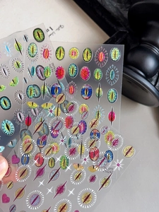 Detailed macro view of cat eye evil eye nail stickers with glitter and holographic finish