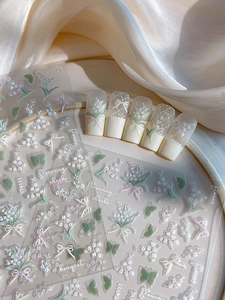 Detail of 3D embossed floral and butterfly nail art stickers in fresh pastel tones