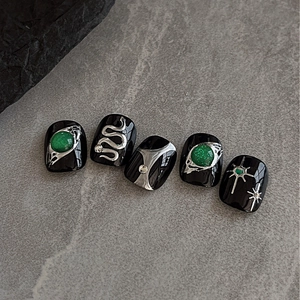 Emerald green gems and silver snake charms on black press-on nails with 3D metal art