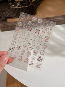 Macro detail of 5D Bohemian mandala embossed nail stickers with gold and red patterns