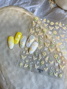 Detail van gele vlinder- en lelietje-van-dalen nagelstickers op gestructureerd vlak