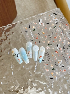 Detail view of 3D embossed koi fish nail stickers with floral motifs and calligraphy