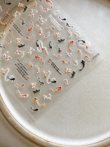 Detail of 3D embossed koi fish and pink lotus floral pattern on nail art stickers
