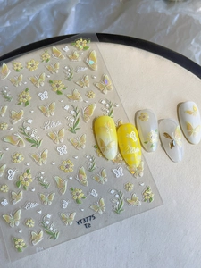 Detail van gele vlinder en lelietje-van-dalen nagelstickers op witte display