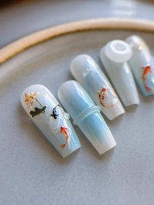 Detail of 3D embossed koi fish and lotus flower nail art stickers on ceramic plate