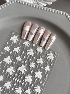 Détail macro de stickers à ongles fleurs en relief et ongles à dégradé rose doux