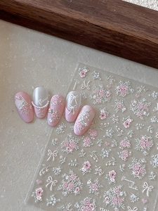 Macro detail of 3D embossed floral nail stickers featuring pink roses and white pearls