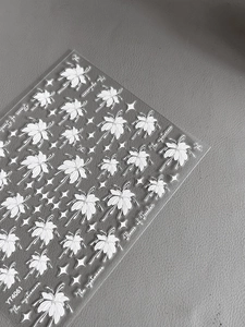 Détail des stickers YT4061 fleurs et étoiles blanches en relief pour nail art sur gris