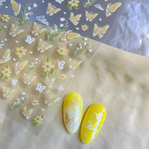 Zelfklevende nagelstickers met gele vlinders en lelietjes-van-dalen en lasereffect