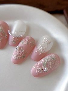 Detail of pink embossed flower nail stickers with 3D pearls and grid patterns