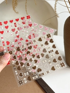 Macro view of 3D embossed nail stickers with heart, bow, and candy patterns