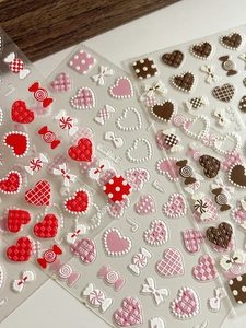 Macro shot of 3D embossed nail art stickers with heart, candy, and bowknot patterns
