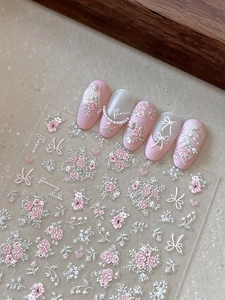 Macro detail of 3D embossed floral nail stickers with pink roses and lace textures