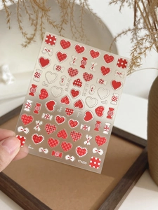 Macro detail of YT4209 nail stickers with 3D embossed hearts, bows and candy patterns