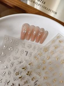 Gros plan détaillé de stickers à ongles 3D en relief avec motifs papillons et fleurs dorés