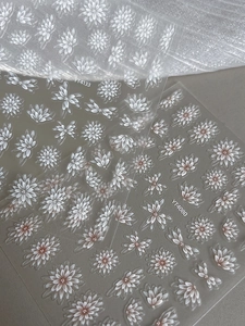 Detailed view of floral nail stickers featuring realistic white daisies and petunias