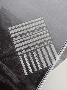Detail of YT4120 white lace nail art stickers with intricate embossed stripe patterns