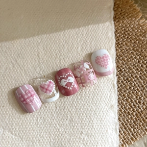 Sweet pink and white press-on nails with 3D bows, heart patterns, and floral details