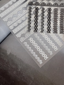 Detailed view of high-transparency lace nail stickers with black and white wavy patterns